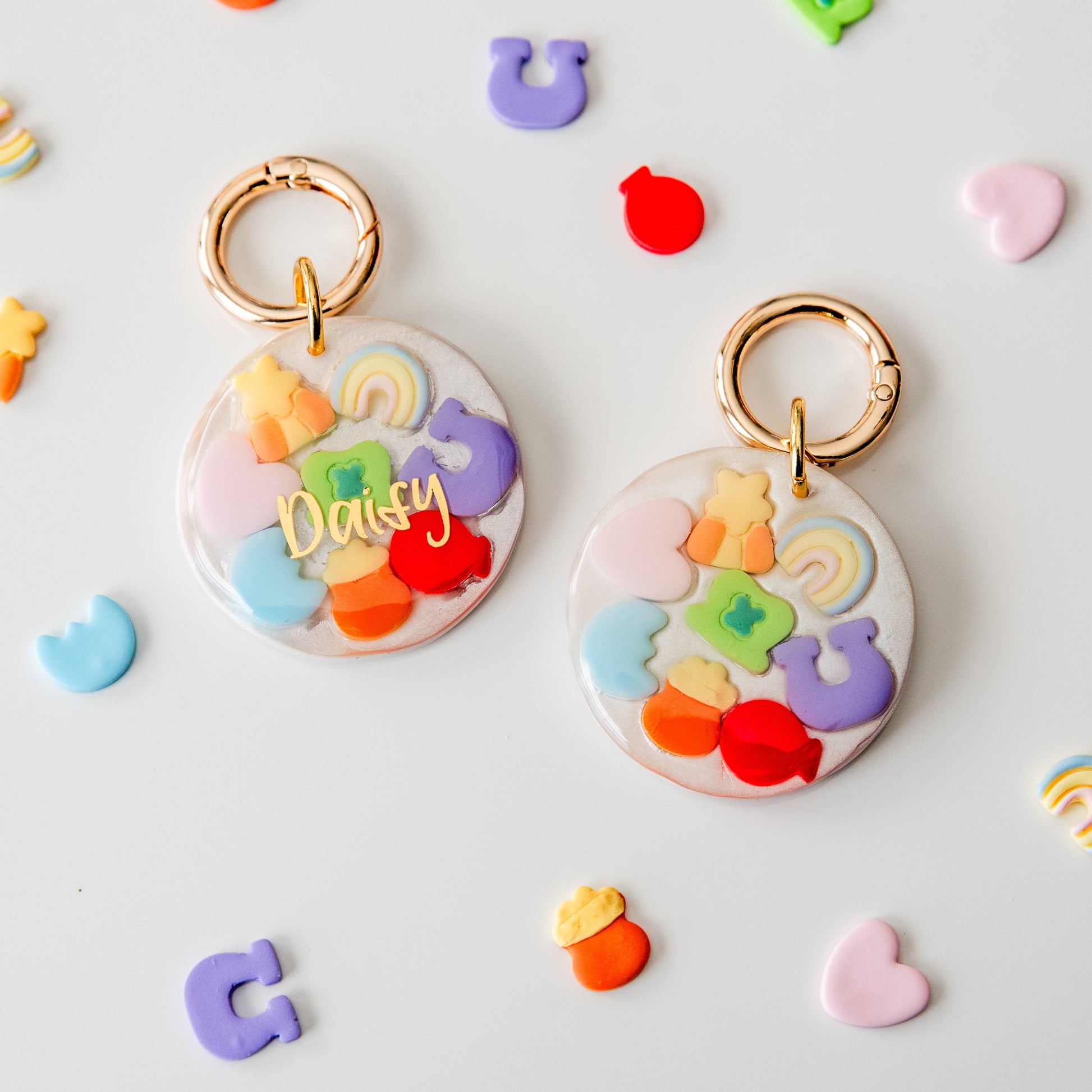 Colorful keychains with letters and shapes on a light gray background
